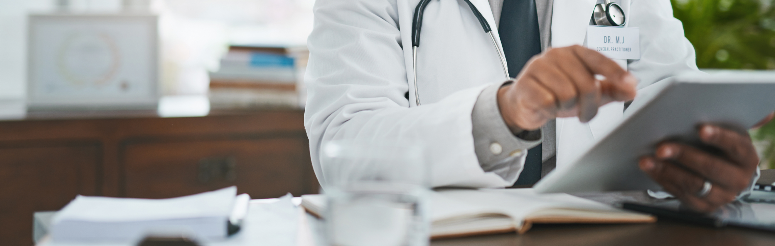 Clinician at a desk holding a pad of paper