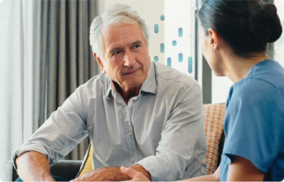 A clinican speaks to a patient sitting beside her in her office